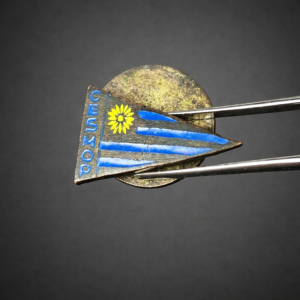 Prendedor triangular CESMOP con bandera uruguaya. Siglo XX.