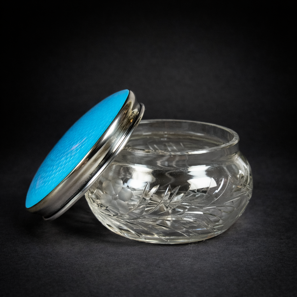 Polvera de cristal tallado con tapa de plata y esmalte guilloché, ca. 1930 Polvera o alhajero antiguo en cristal y esmalte celeste. Circa 1930.