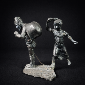 Escultura antigua en metal; niño y mendigo contando monedas. Circa 1900.
