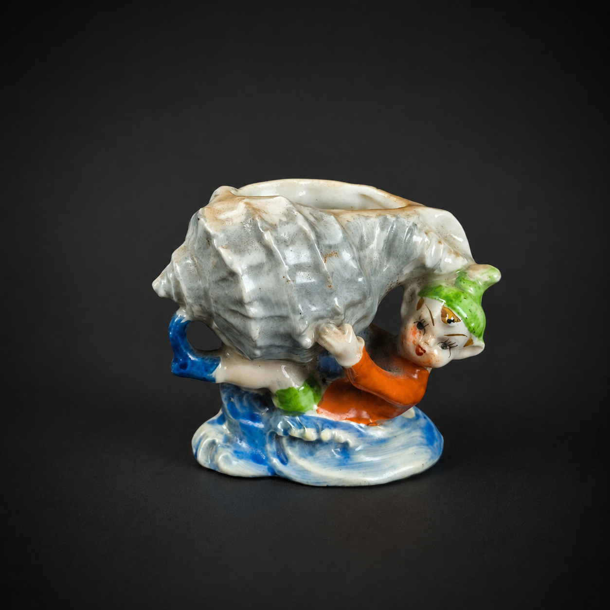 Pieza decorativa de elfo con caracol sobre ola, ca. 1950. Pieza decorativa de elfo con caracol sobre ola, ca. 1950.