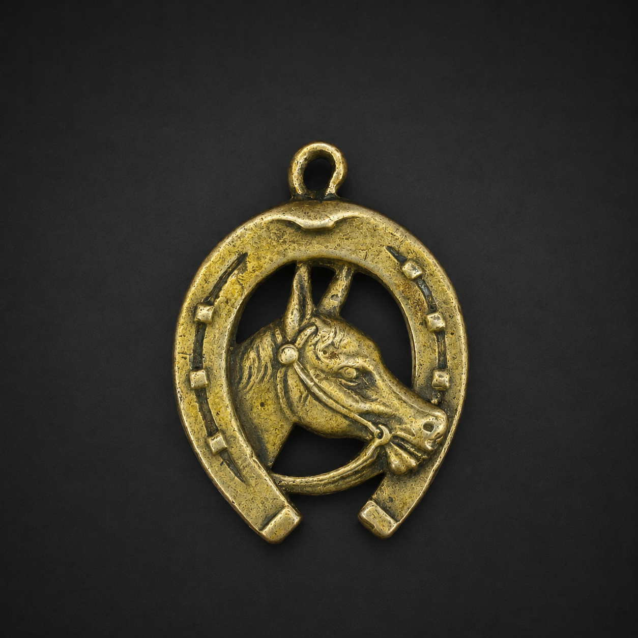 Dije ecuestre de bronce con herradura, ca. 1950. Dije ecuestre de bronce con herradura, ca. 1950.