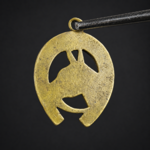 Dije ecuestre de bronce con herradura, ca. 1950.
