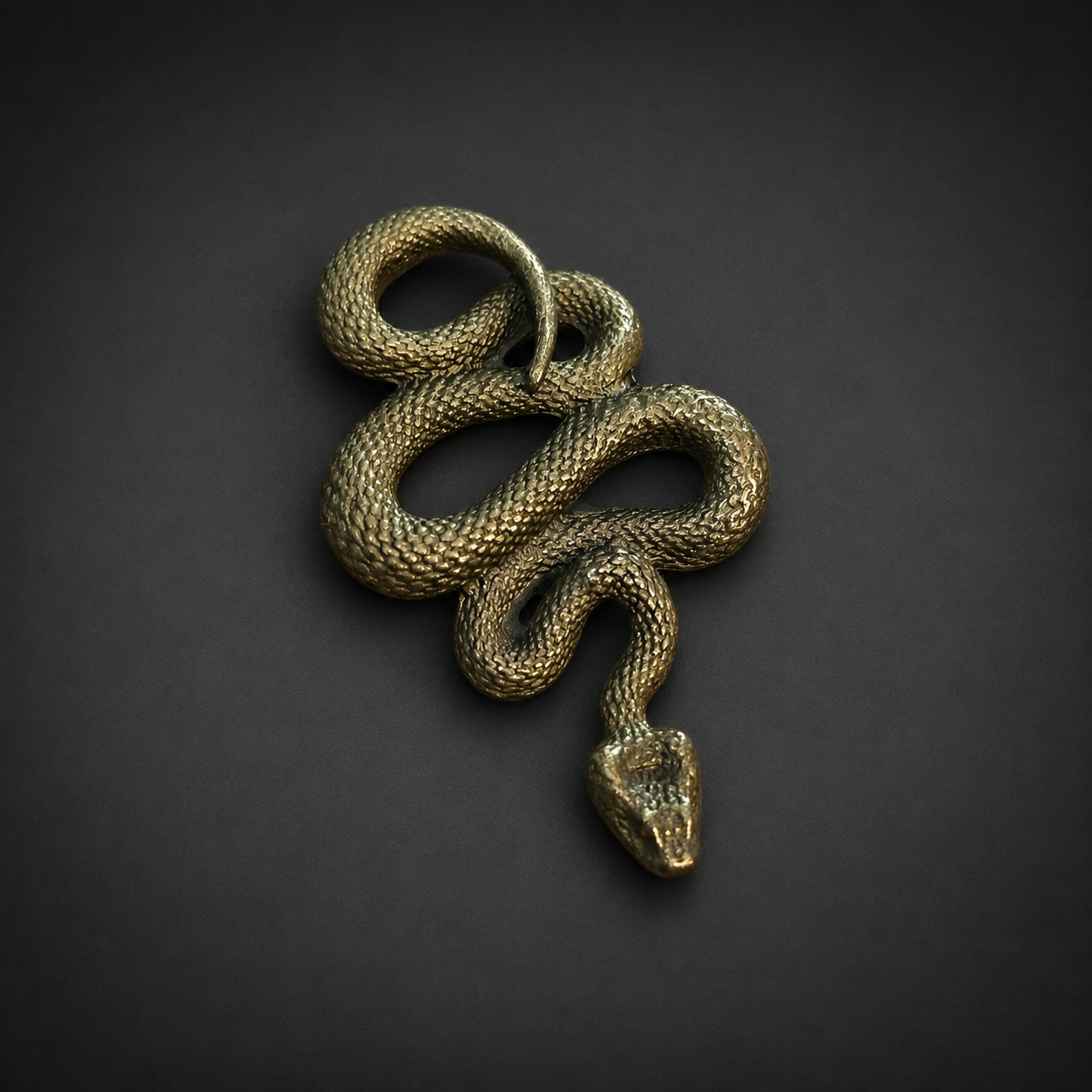 Dije de serpiente en latón, siglo XXI. Dije de serpiente en latón, siglo XXI.