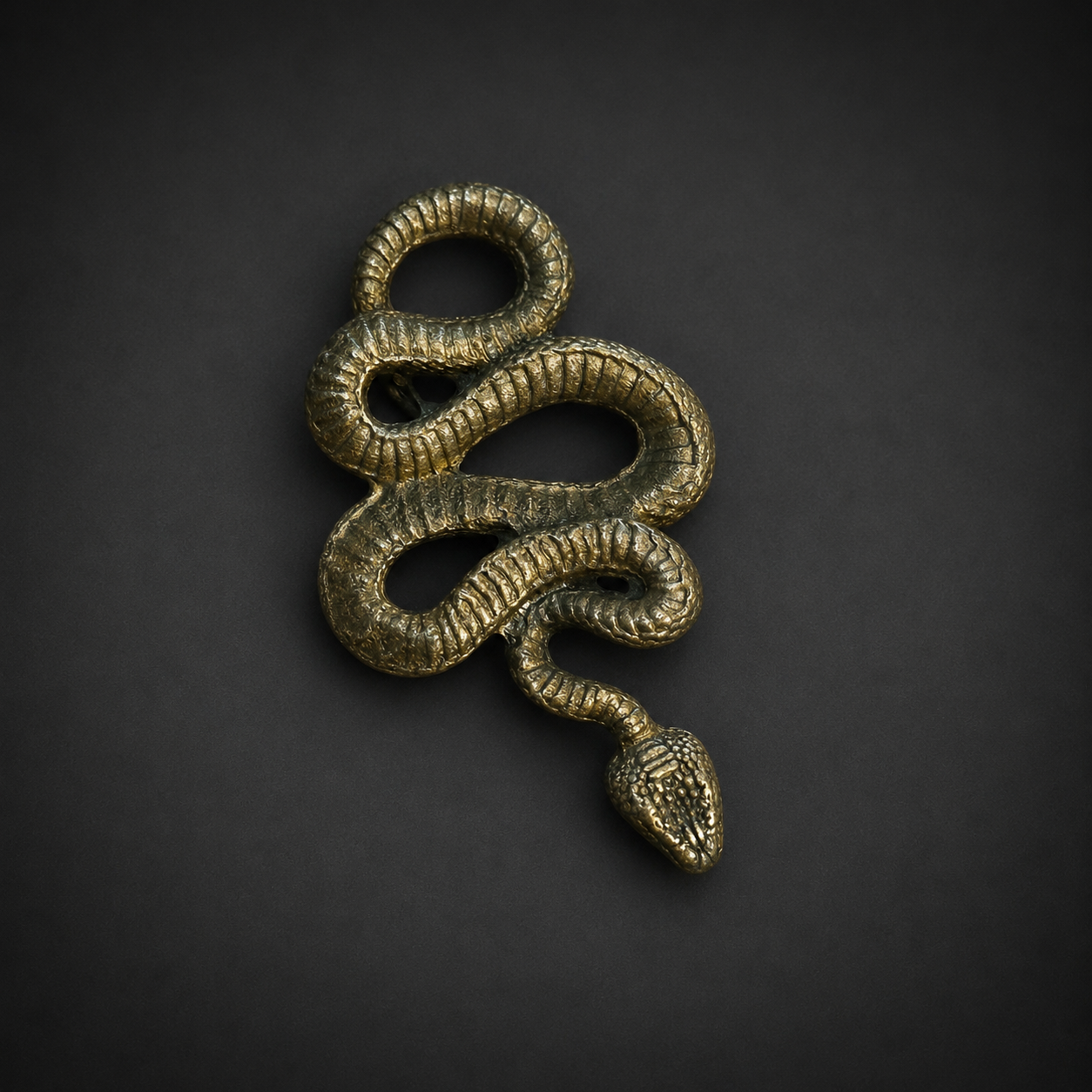 Dije de serpiente en latón, siglo XXI. Dije de serpiente en latón, siglo XXI.