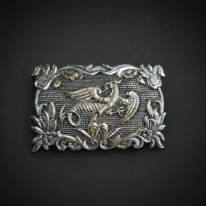 Prendedor con grifo en metal plateado, ca. 1950.