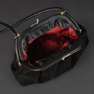 Cartera de gamuza negra con cierre kiss lock, ca. 1950.