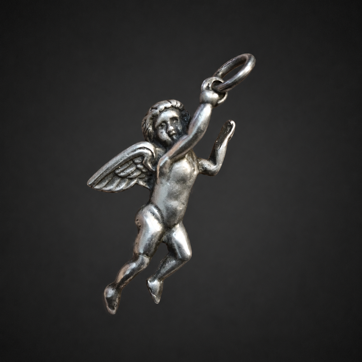 Dije de querubín alado en plata, ca. 1950. Dije de querubín alado en plata, ca. 1950.